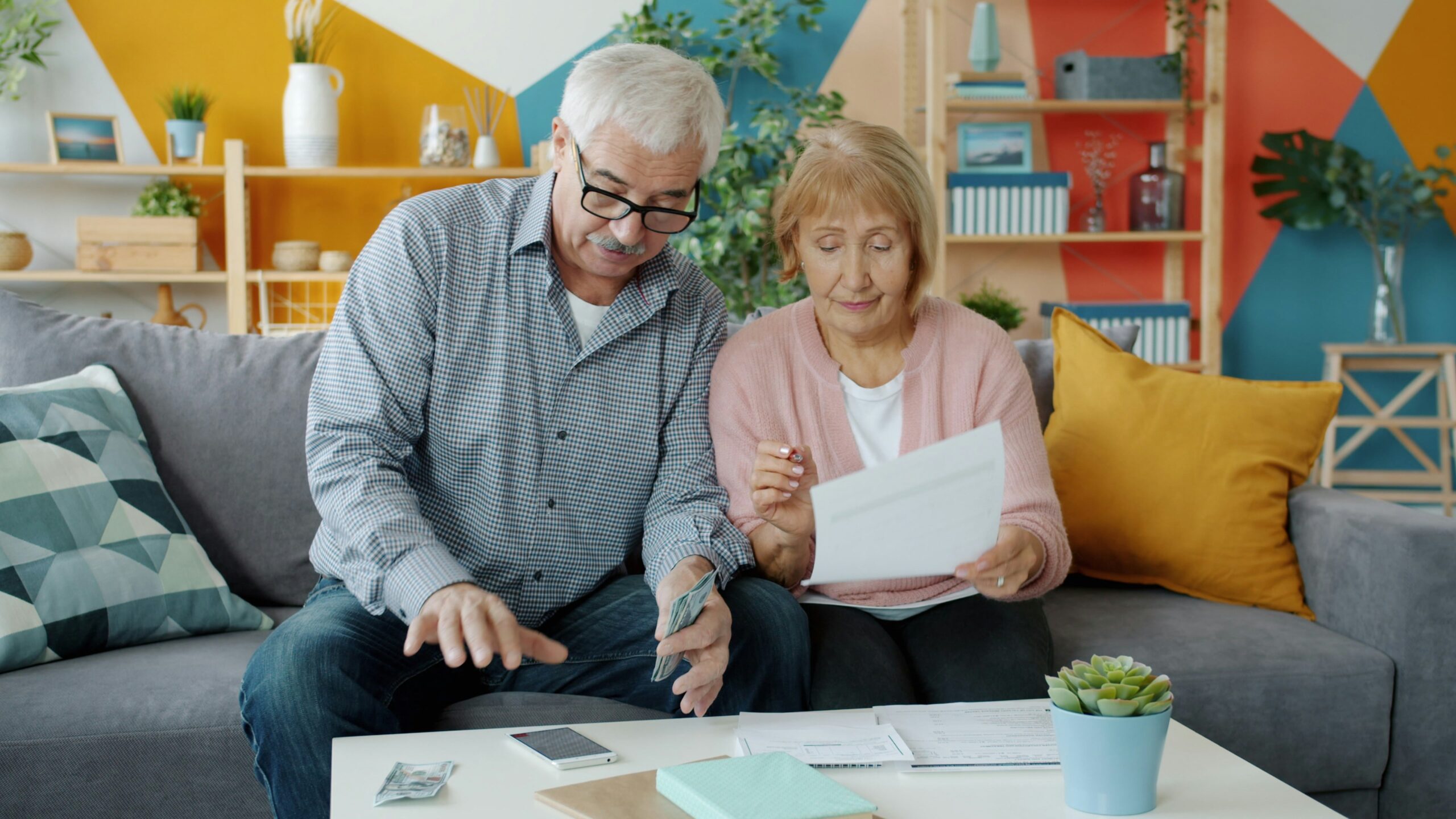 Older couple reviewing bills and FEGLI costs at home
